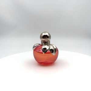 Flacon rose en forme de pomme du parfum Nina Eau de Toilette de Nina Ricci