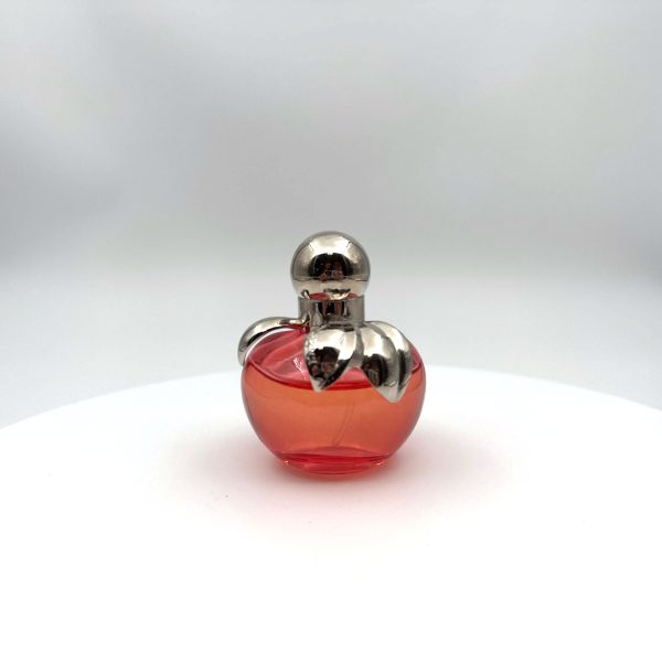 Flacon rose en forme de pomme du parfum Nina Eau de Toilette de Nina Ricci